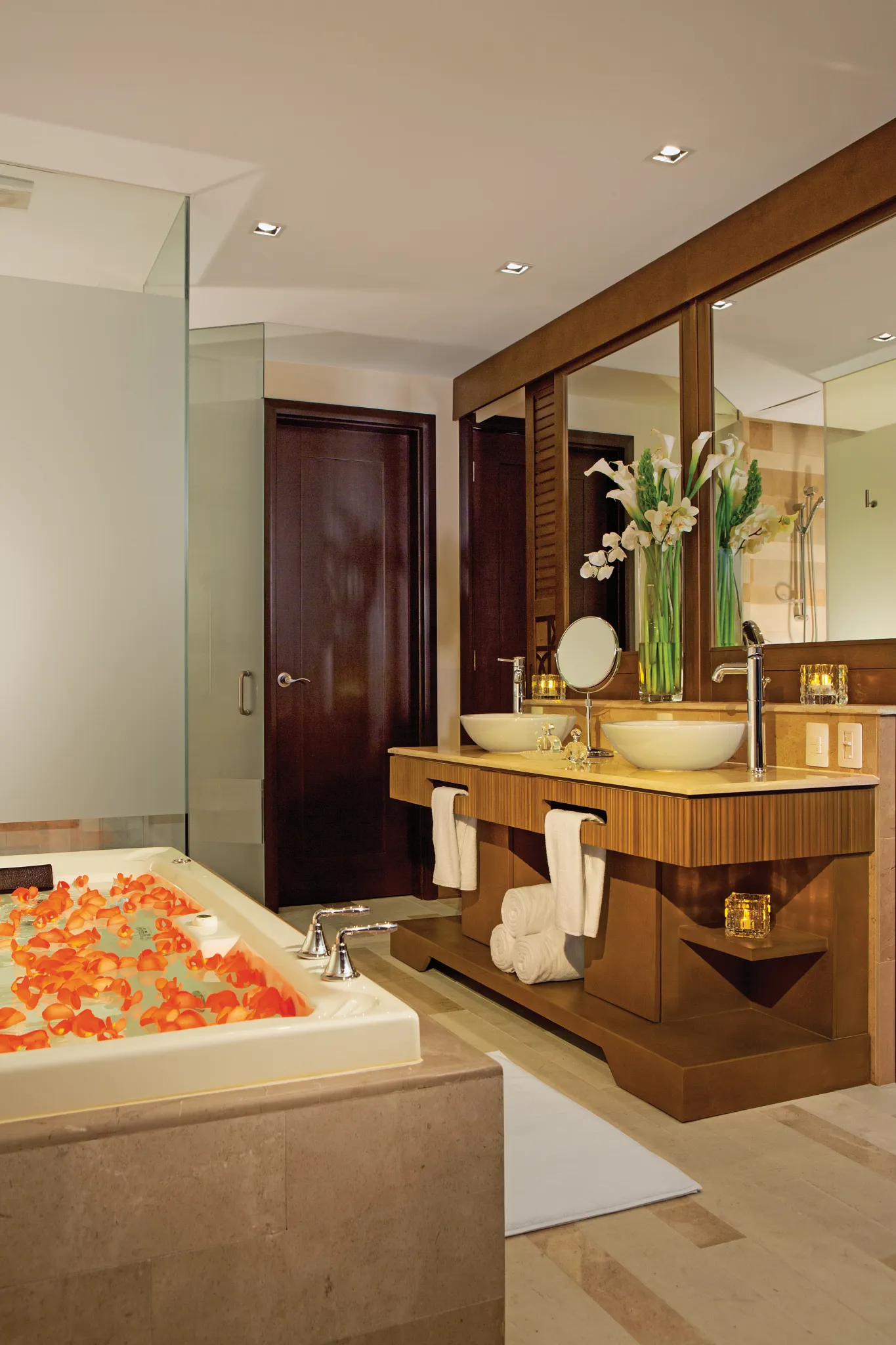 bathroom with two sinks, a bath tub, and a shower