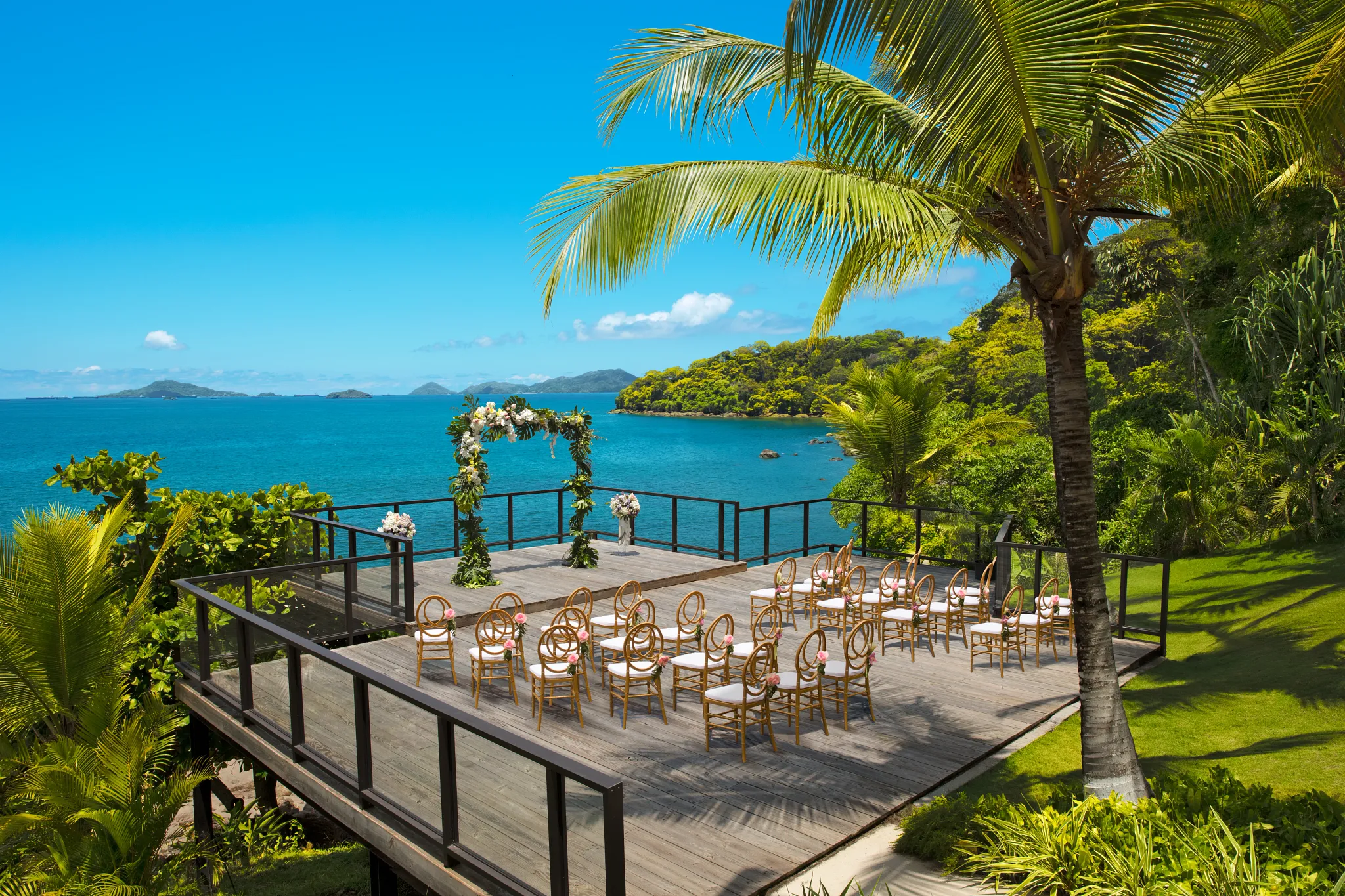 Deck Set up With Chairs for Tropical Outdoor Wedding Ceremony Overlooking an Ocean Backdrop