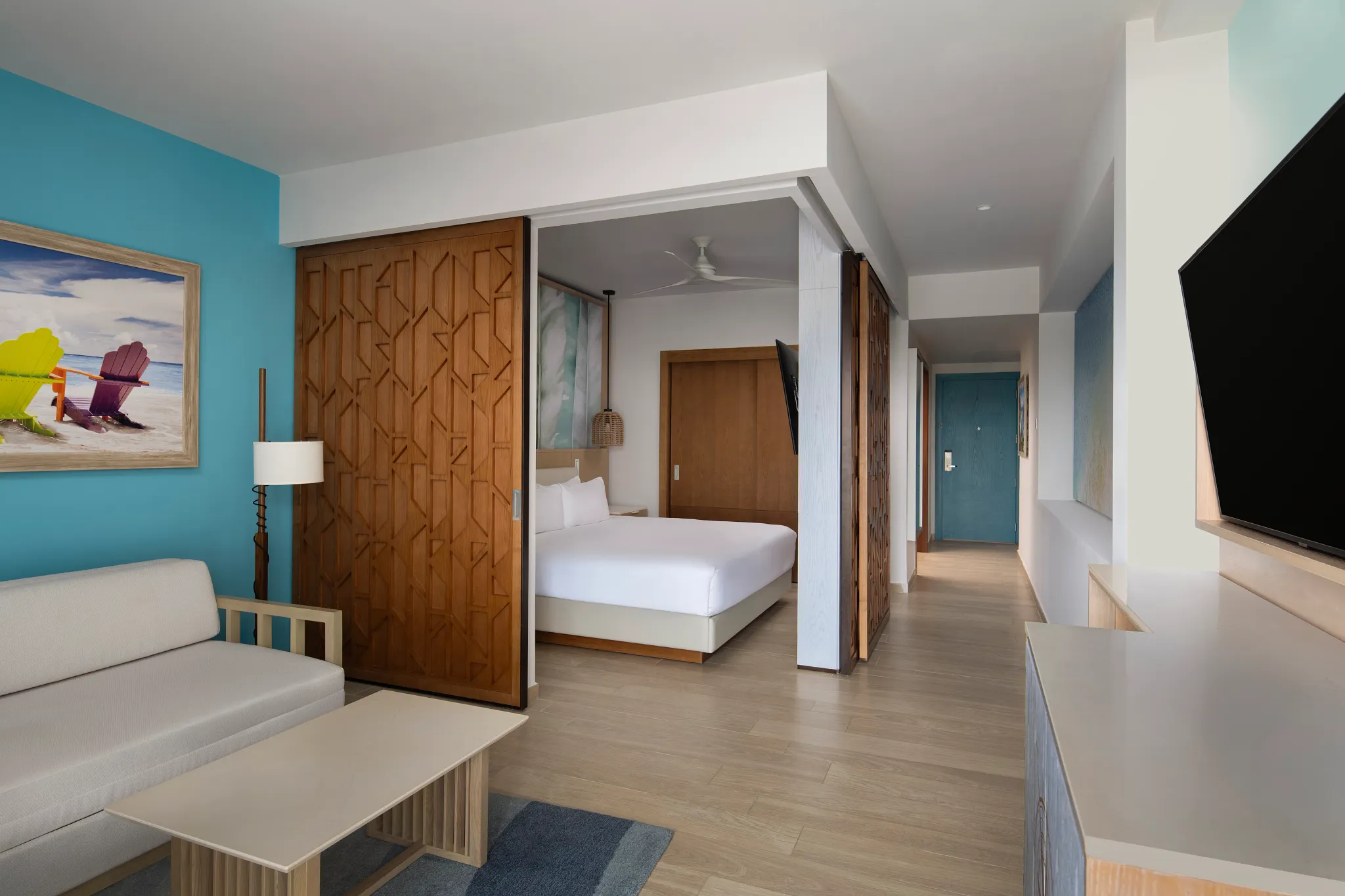 Room with king bed in a cut out area and sitting area with tv