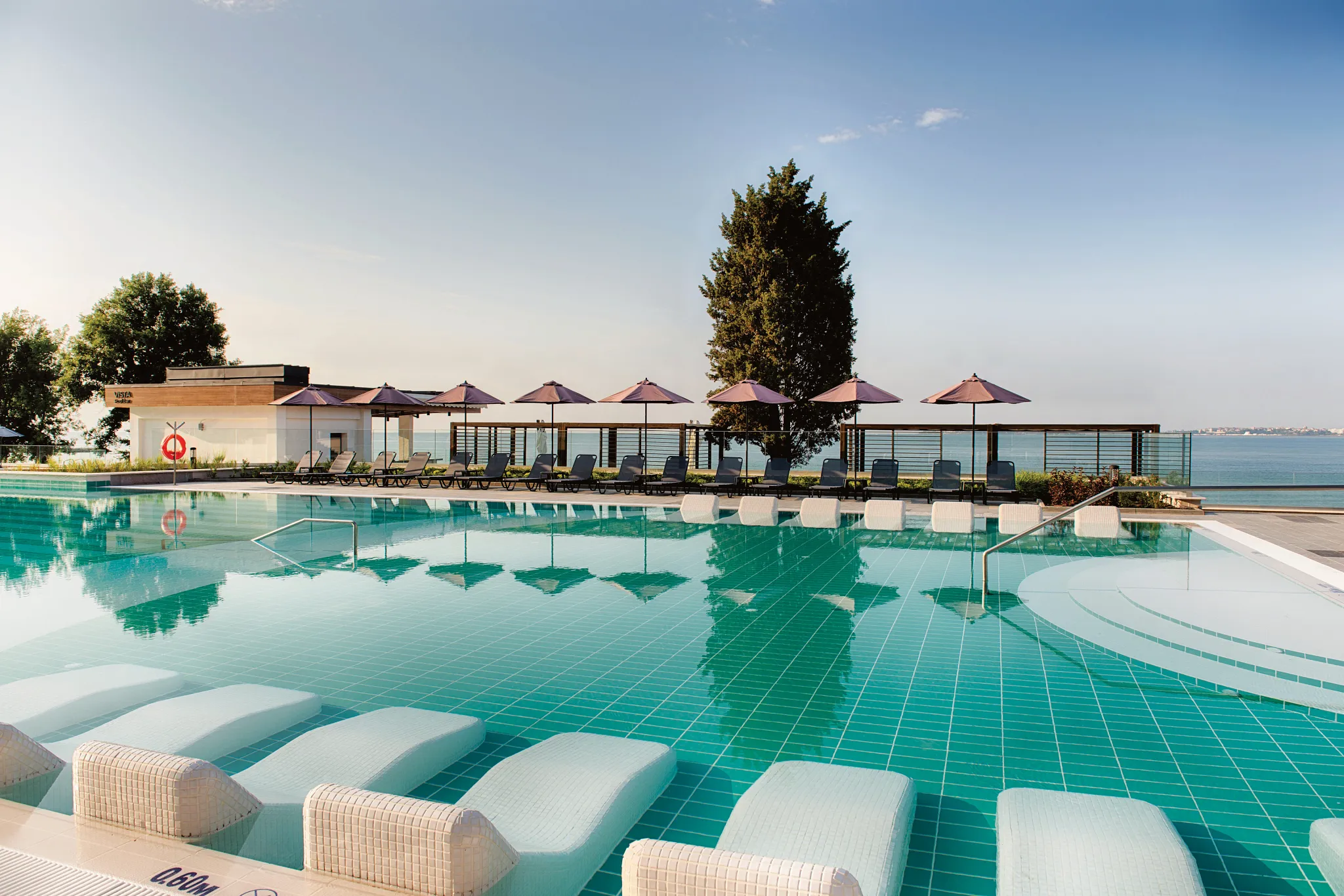 Pool area with sunbeds and beach umbrellas