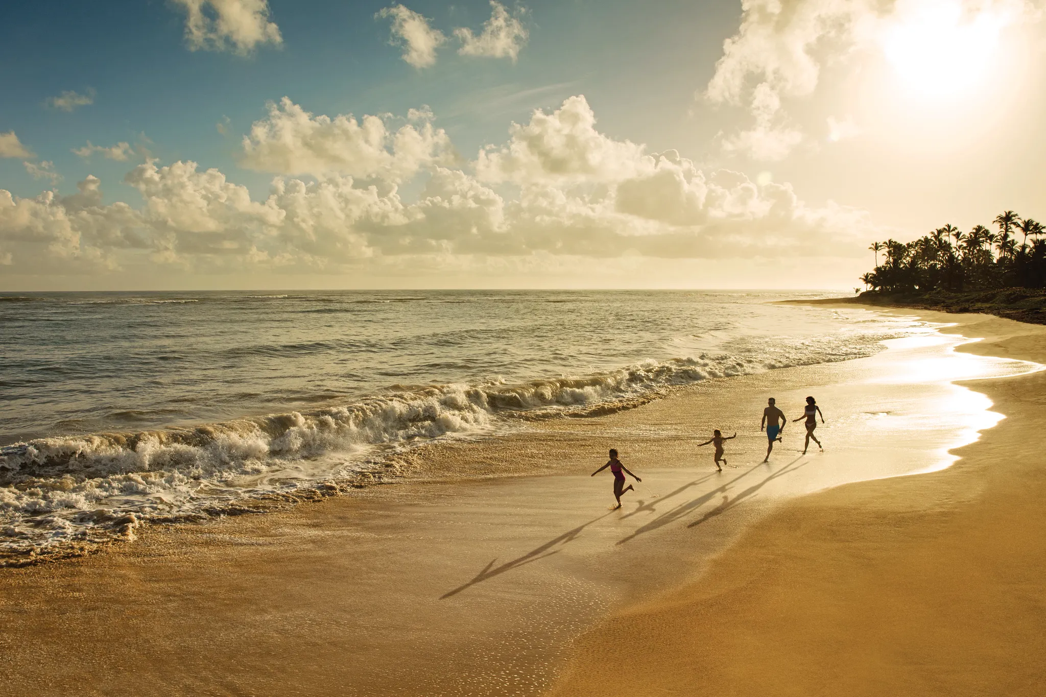 Family walking on the beach at sunset