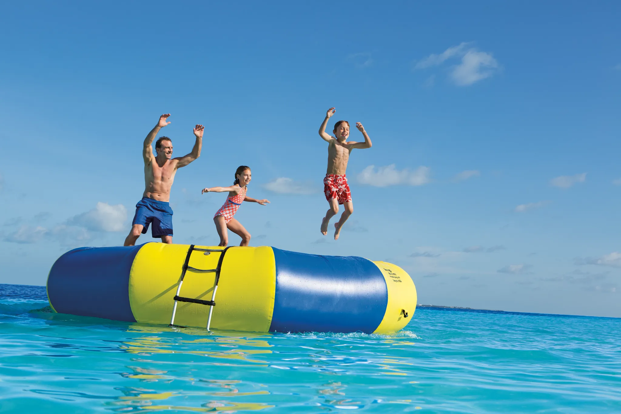 Kids jumping on an inflatable beach trampoline