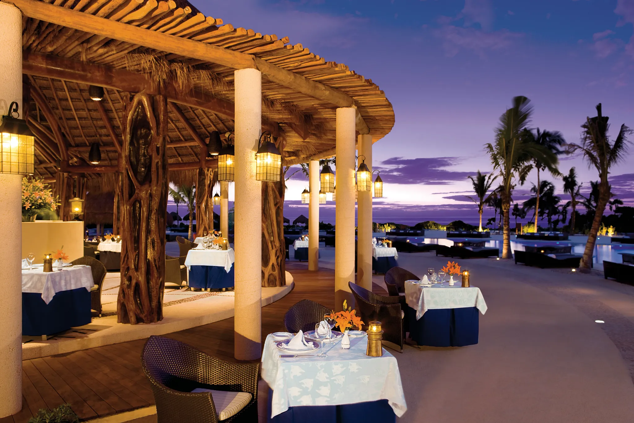 Open air restaurant overlooking the ocean at dusk