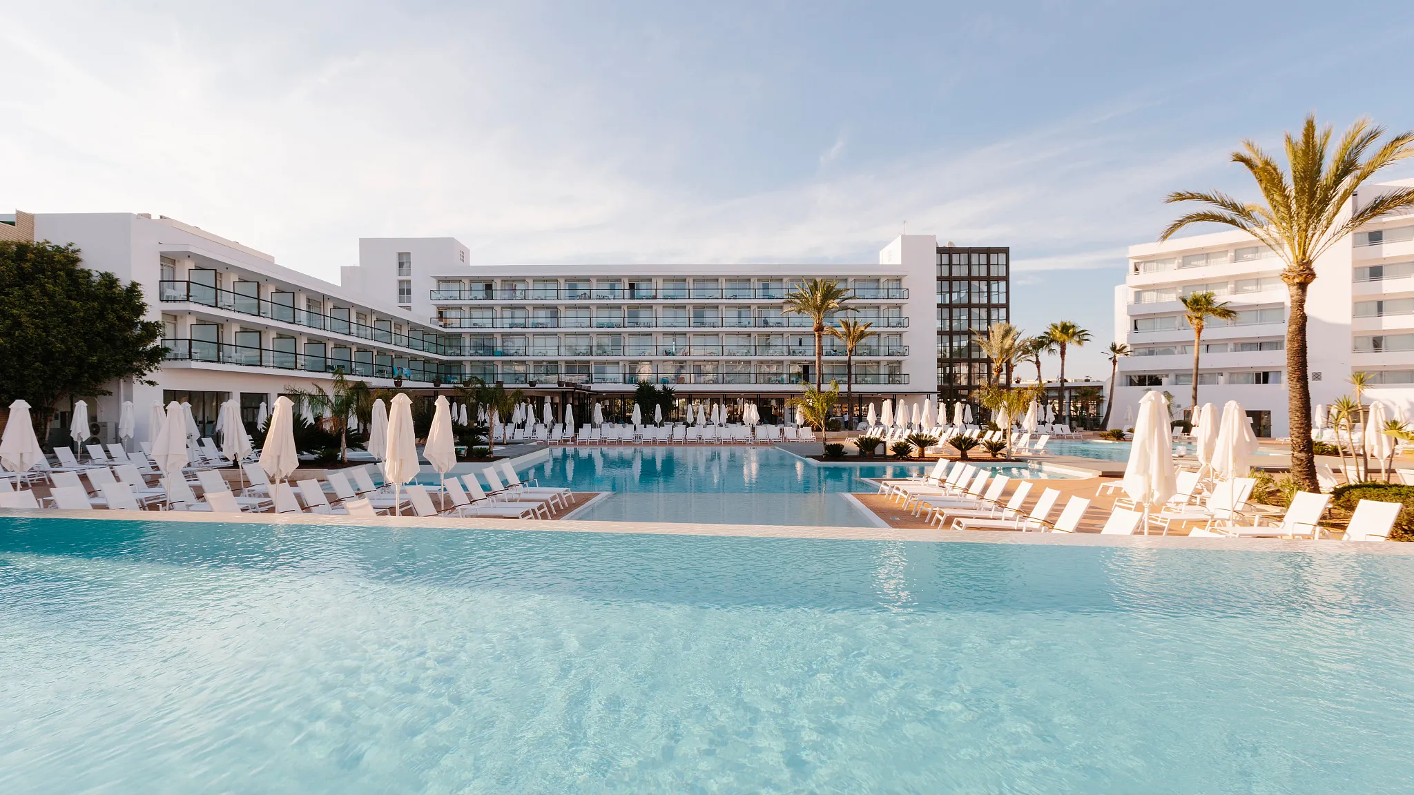 Resort and pool with lounge chairs and palm trees