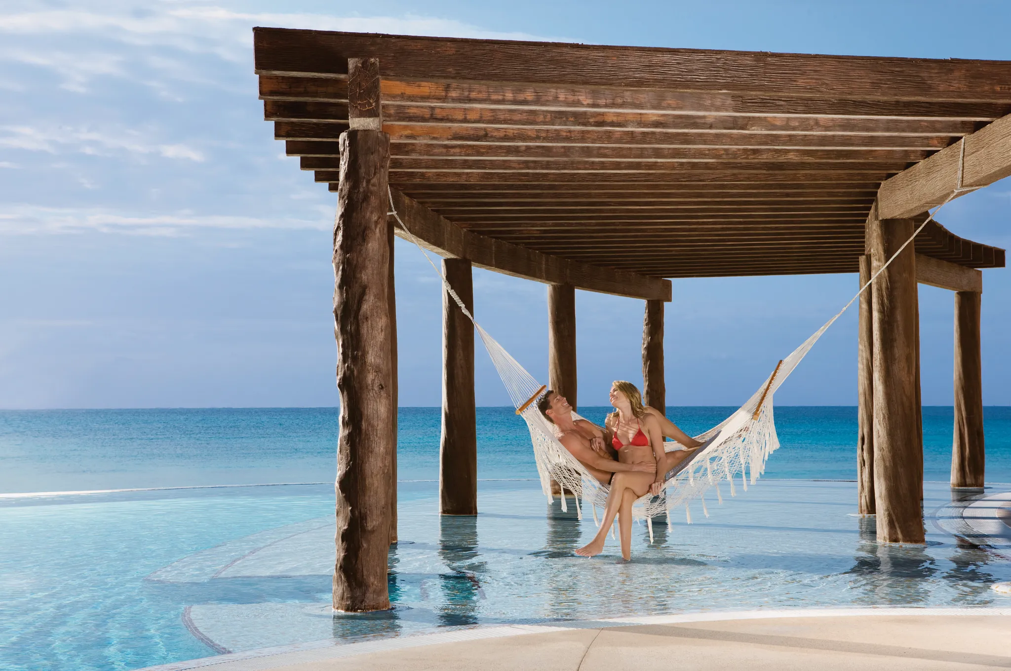 couple sitting on Poolside hammocks