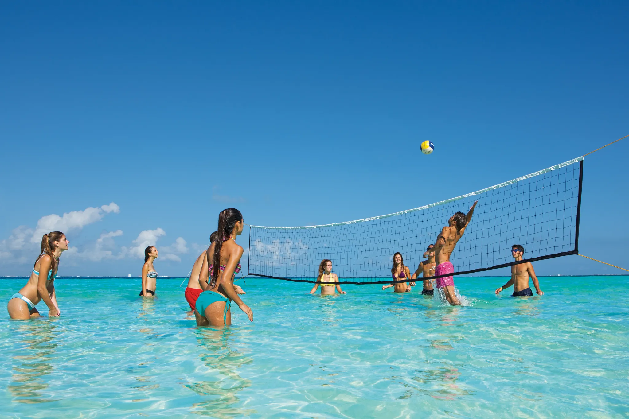 People playing volleyball in the ocean