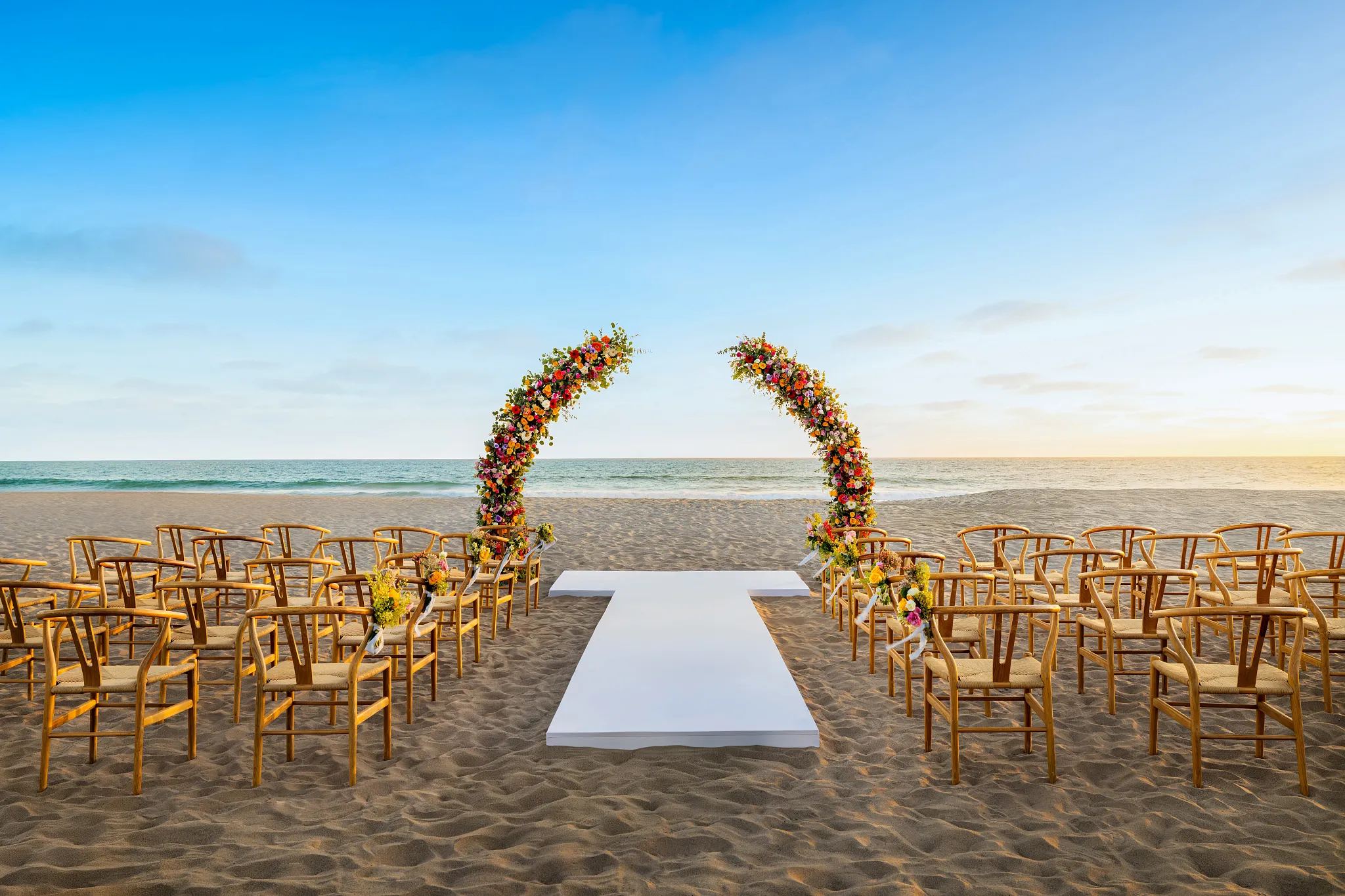 Wedding setup on the beach with flowers and a walkway and views of the ocean