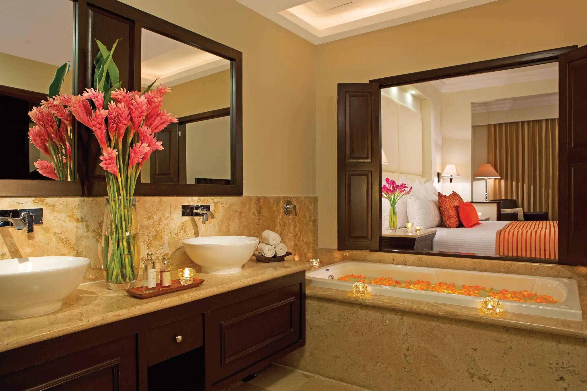 bathroom with a two sink vanity, bathtub, and view into bedroom