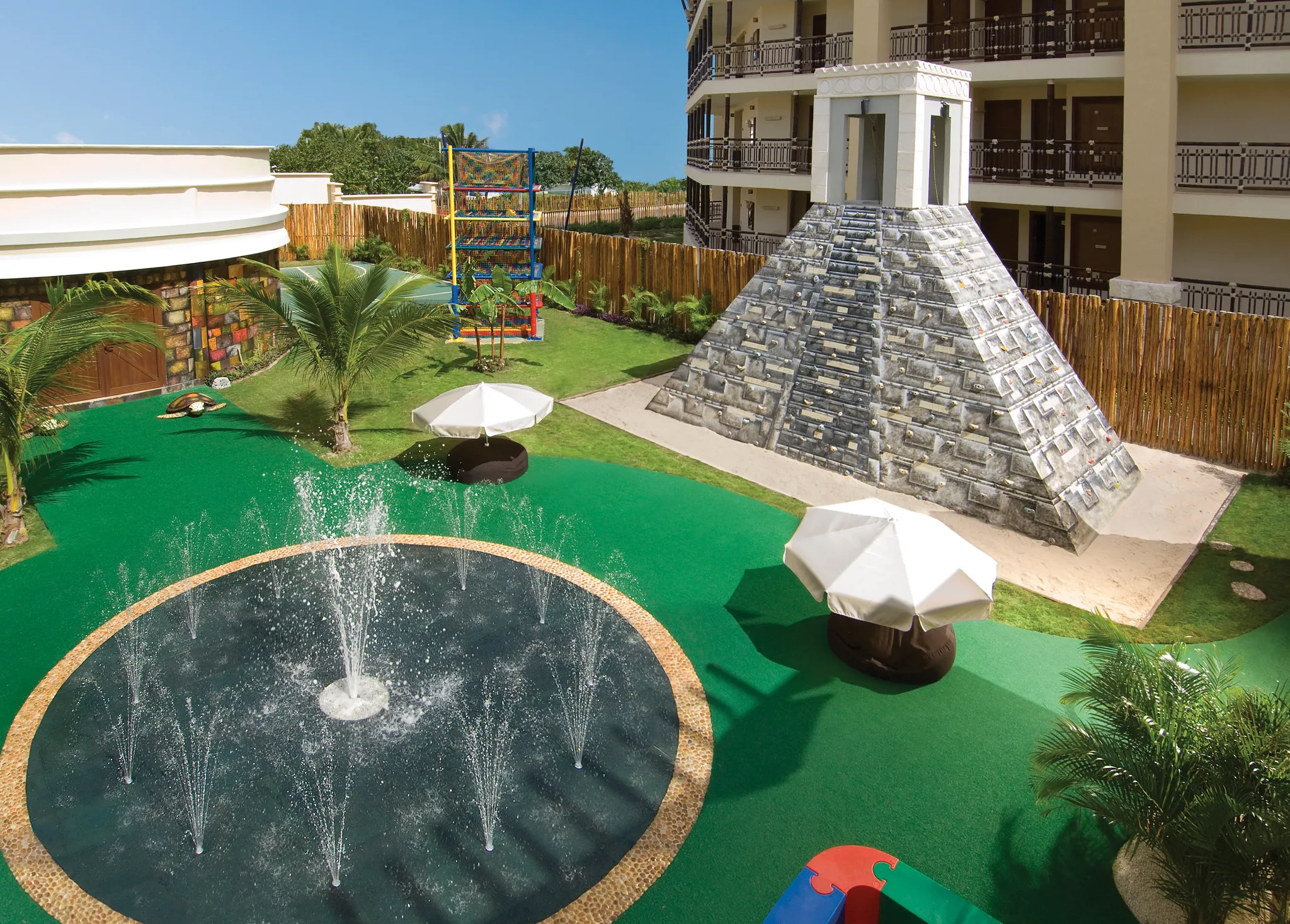 Outdoor area of the Explorer's Club with center water fountain and Aztec inspired rock climber