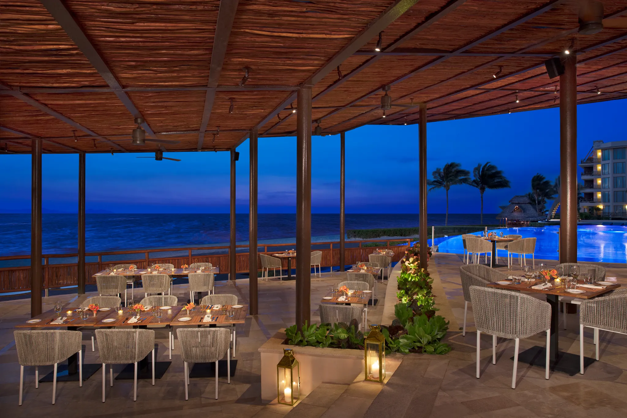 Beach and pool side restaurant with tropical decor and open air layout